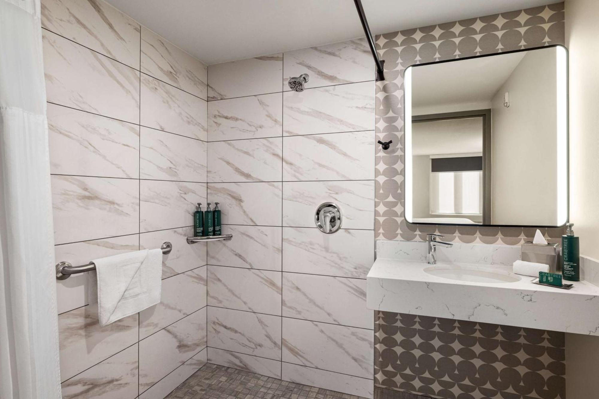 Quarto com cama king-size e chuveiro acessível a cadeirantes - Acessível para pessoas com mobilidade reduzida/deficiência auditiva