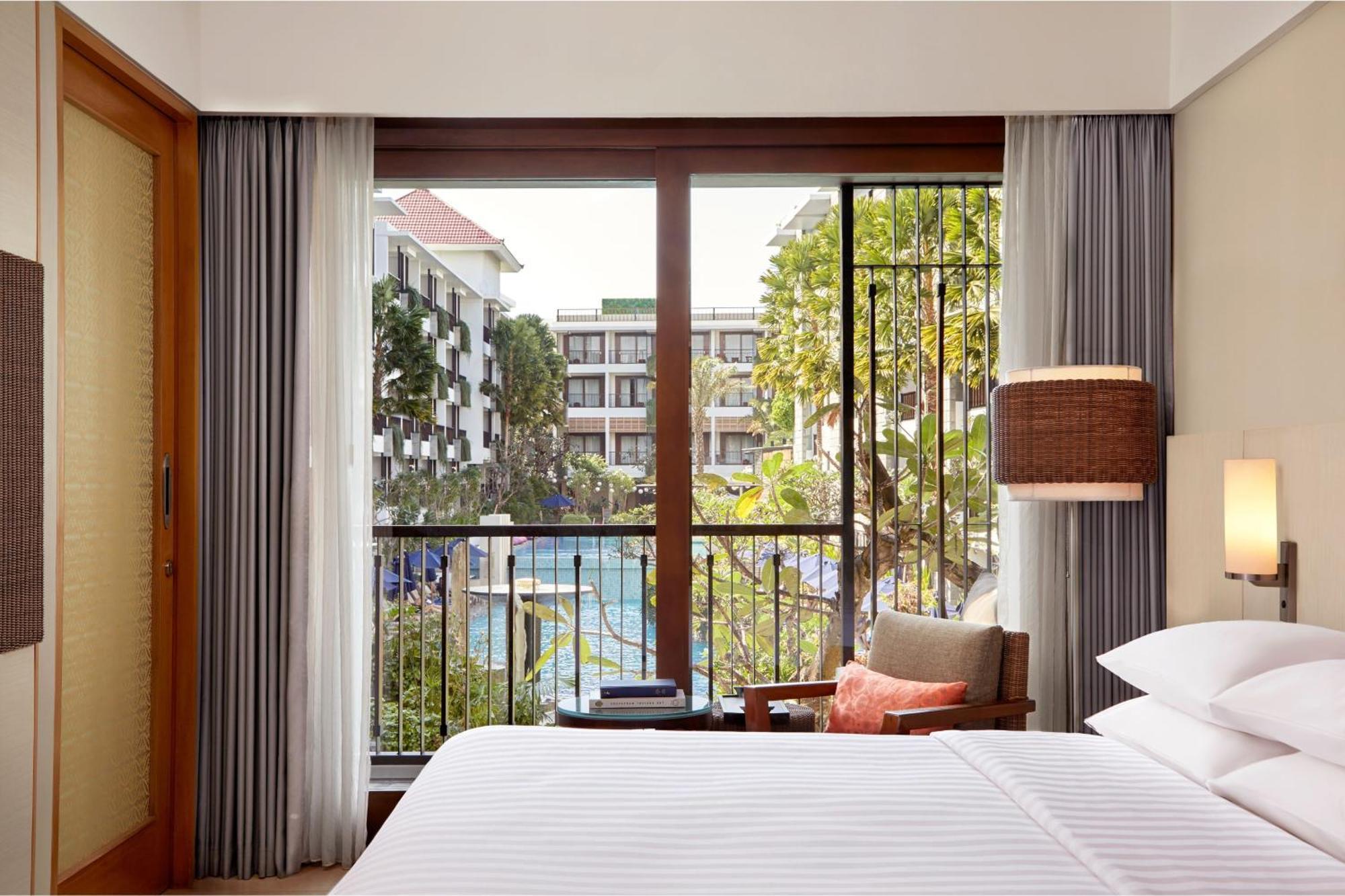 Deluxe Zimmer mit Kingsize-Bett und Poolblick.