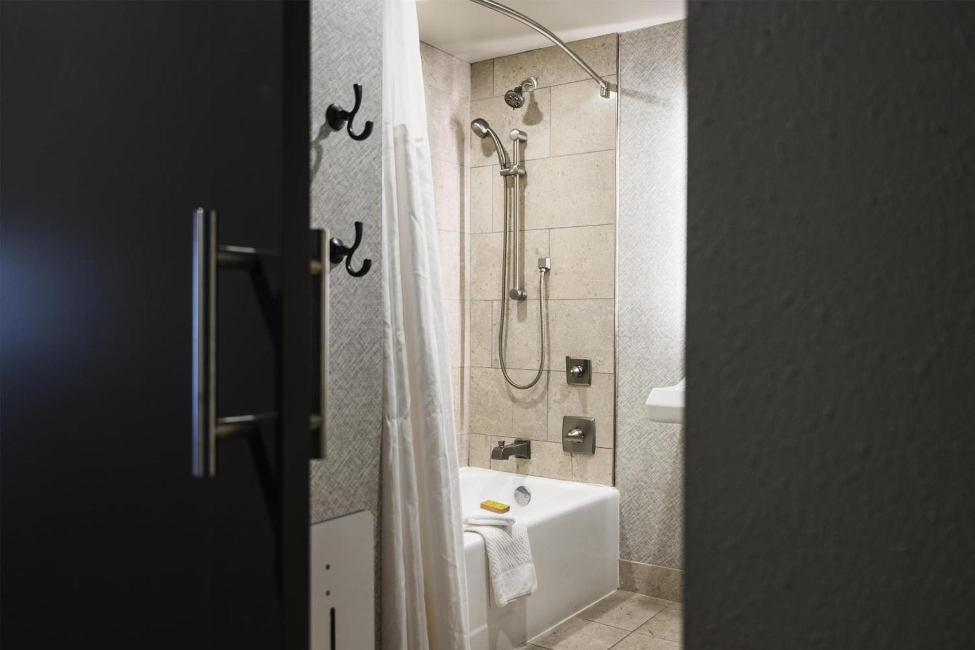 Habitación con cama extragrande y bañera adaptada para personas con movilidad reducida